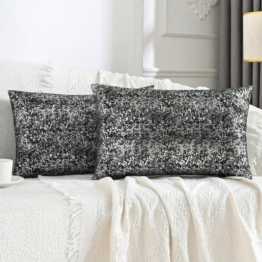 Two black sequin pillows on a white bed in a bedroom setting.