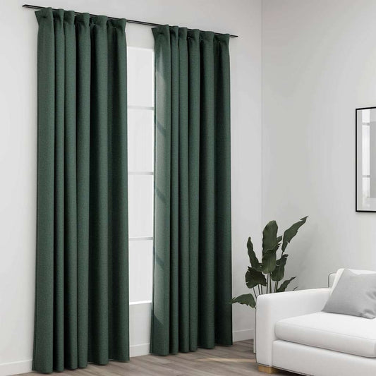 Green curtains on a window with a white wall and a white sofa in the background